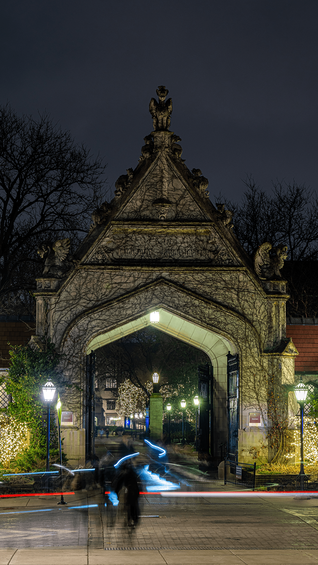 Gothic arch at night with time lapse traffic lights passing in front.